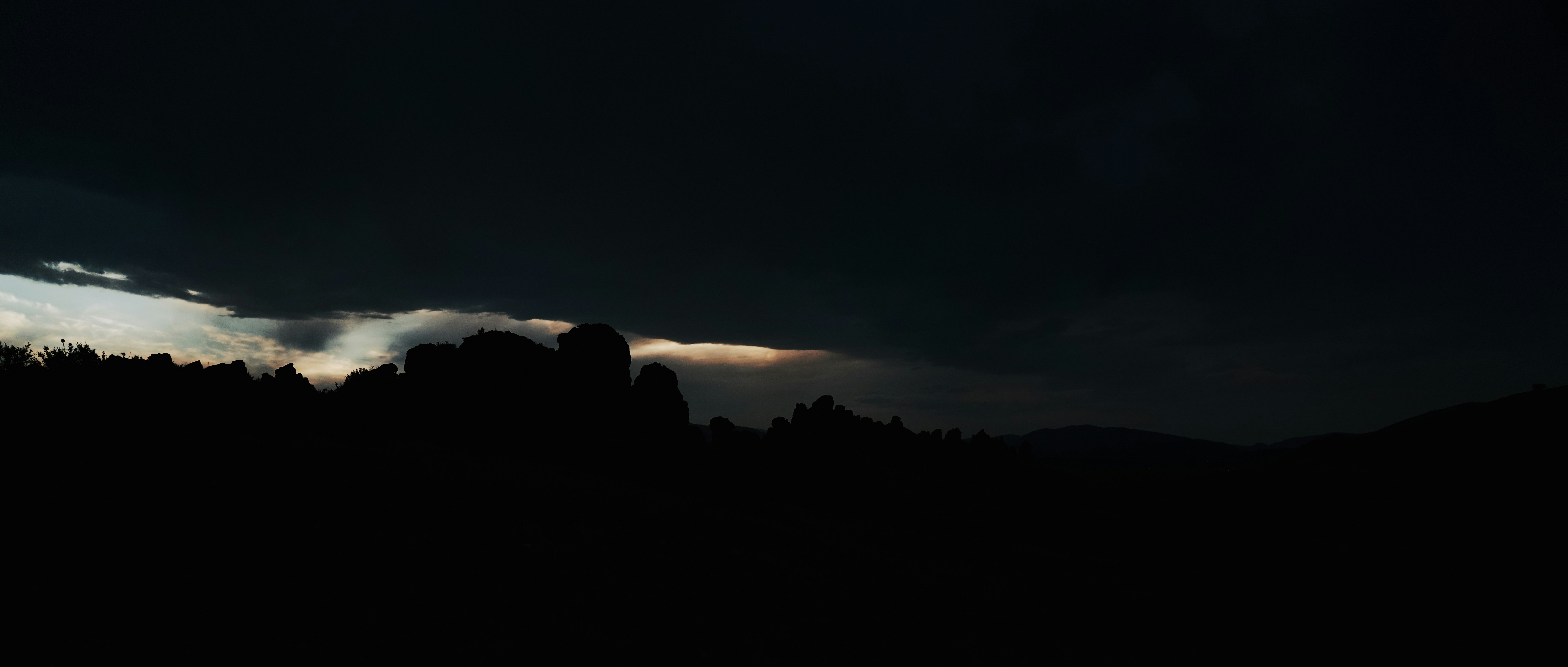 silhouette of trees under cloudy sky during sunset